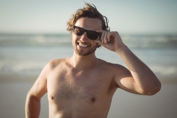 Wall Mural - Portrait of shirtless man wearing sunglasses at beach