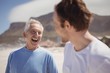 © WavebreakMediaMicro - Cheerful senior man with his son standing at beach
