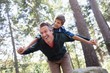© WavebreakMediaMicro - Cheerful father piggybacking son in forest