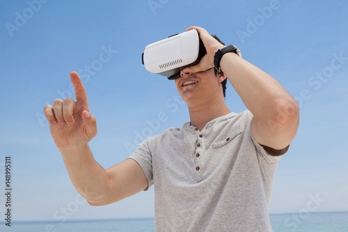 Fotografie, Obraz Man using vr headset against the blue sky