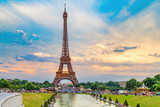 Fototapeta Boho - Eiffel tower, view from Trocadero park over fountain. People making their evening promenade around fountain. Eiffel tower is famous symbol of Paris city and France. Sunset scenery, epic dramatic sky.