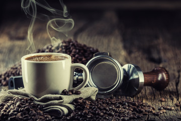 Coffee. Cup of black coffe with coffee beans tamper and portafilter.