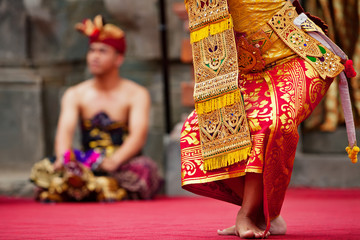 Wall Mural - Asian travel background. Beautiful Balinese dancer woman in traditional Sarong costume dancing Legong dance. Legs movements. Arts, culture of Indonesian people, Bali island festivals.