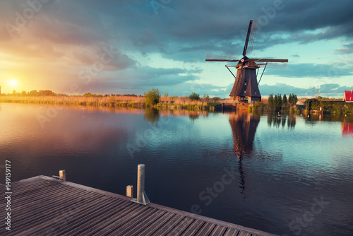 Fotografija Landscape with tulips, traditional dutch windmills and houses near the canal in Zaanse Schans, Netherlands, Europe
