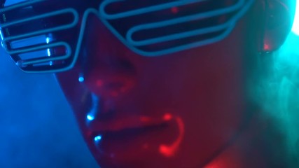 Wall Mural - Closeup face of female mannequin in blue glowing led glasses over dark smokey background