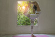 © kayasit - Young woman practicing yoga with indoor home interior background,