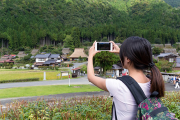 Wall Mural - Woman taking photot on cellphone in miyama