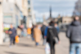 Fototapeta Zachód słońca - Blurred image of People walking on the street, with car, building in background. On Princes Street, the main shopping street in Edinburgh, United Kingdom.