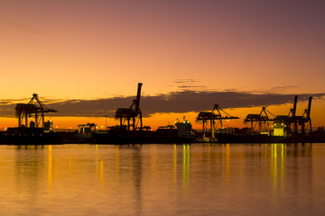 Container Cargo freight ship with working crane bridge in shipyard at dusk for Logistic Import Export background