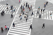 Menschen überqueren eine Straßenkreuzung in Tokyo, Japan