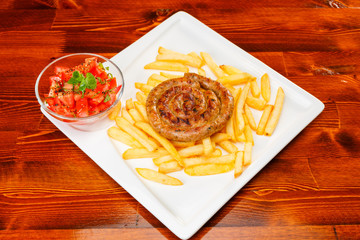 Fire grilled sausage with fries and tomato salad