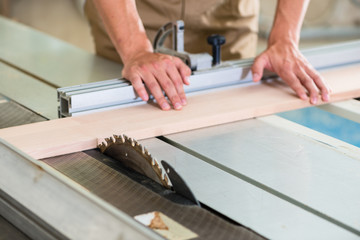 Wall Mural - Carpenter cutting wooden board with circular saw