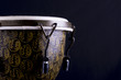 Image of a wooden bongo drum on a black background.