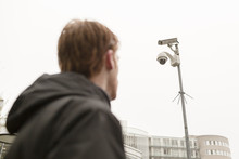 Man Looking At Security Camera Outdoors