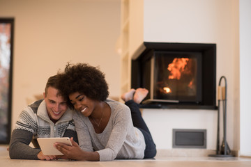 multiethnic couple using tablet computer on the floor