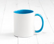 simple white cup with blue inside and handle on a planked table