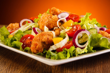 Wall Mural - Fried chicken nuggets with vegetable salad