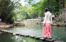 Girl Walking On The Stone Bridge In The River