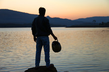 Young Man Standing  Nearby Lake In Holiday Morning
