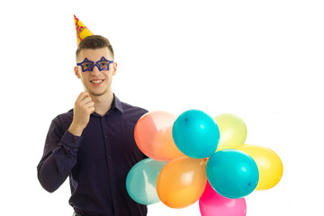 perky young guy keeps near eye paper glasses and lots of colored balls