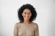 © wayhome.studio  - Carefree and relaxed pretty young mixed race female wearing big round eyeglasses smiling broadly, feeling excited about spending vacations abroad, standing isolated at white blank studio wall