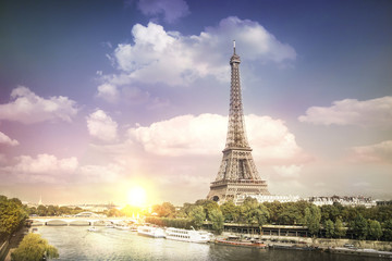 Wall Mural - Eiffel tower sunset with clouds. Romantic sunset background. Old Monument with boats on Seine river in Paris, France.