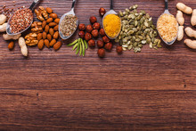 Assorted Nuts On Wooden Surface. Peanuts, Almonds, Hazelnuts, Pumpkin Seeds, Walnuts, Rice, Buckwheat. Top View With Copy Space.