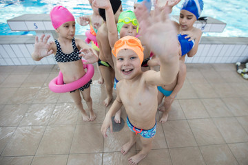 Wall Mural - happy children kids group at swimming pool class learning to swim