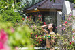 Woman taking shower outside in tropical green Bali garden with a lot flowers. Fresh splashes of clean water. Luxury spa