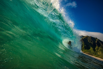 Wall Mural - ocean wave barreled. surfing sport activity in tropical water. blue and green colors on background