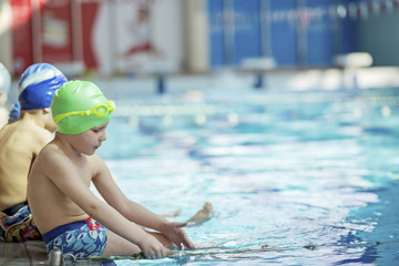 Wall Mural - happy children kids group at swimming pool class learning to swim