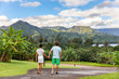 © Maridav - Couple tourists walking on Hawaii vacation. Two young people relaxing in Hanalei Bay resort in Kauai, Hawaii travel beach destination with Kauai mountains in the background.