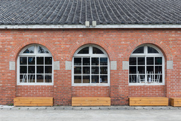 White painted wood with three red bricks wall arched windows