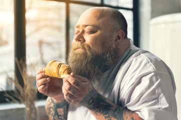 Hungry man smelling croissant