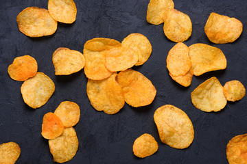 Wall Mural - Potato chips on dark background