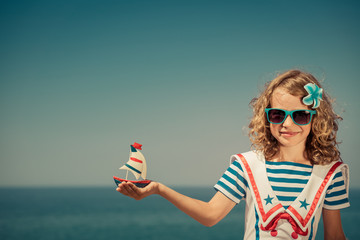 Child with sailing boat on summer vacation