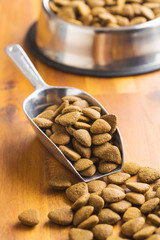 Dry kibble dog food in scoop.