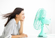 © Tom Wang - smiling woman cooling herself by electric fan