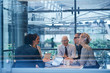 © Connect Images - Window view of businesswomen and men having discussion in conference room