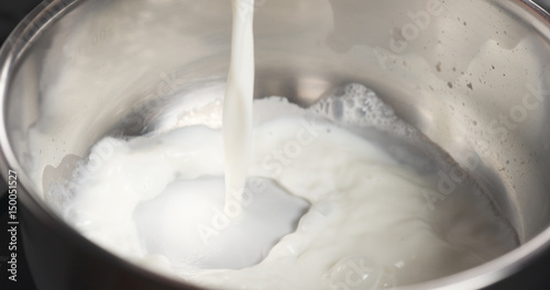 Fotomural shot of pouring milk into saucepan, 4k photo