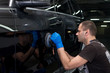© zhekkka - A man polishes a black car