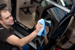 A man polishes a black car