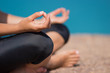 © polinabelphoto - A young woman meditates with ocean views. Hand close-up