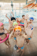 Wall Mural - happy children kids group at swimming pool class learning to swim