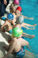 Wall Mural - happy children kids group at swimming pool class learning to swim