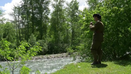 Wall Mural - man with old french military uniform, smoking cigarette near the river