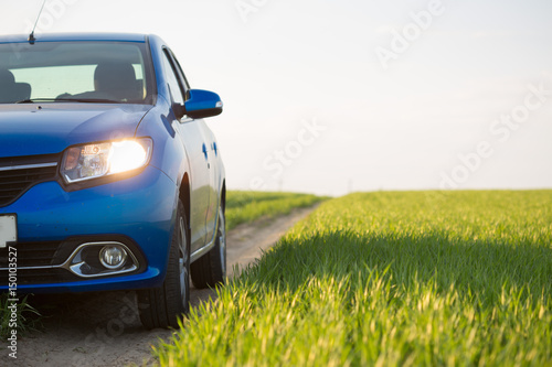 gomel-belarus-6-may-2017-blue-car-renault-logan-parked-in-a-field-on-a-country-road