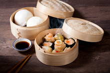 Dim Sum And Steamed Buns In Bamboo Steamer On White Background