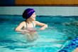 © Iryna - Little girl learning to swim and laughing in big sport pool. Swimming school for small children. Healthy kid enjoying active lifestyle.