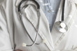 Medical doctor on white background holding a stethoscope. Focus on the stethoscope.